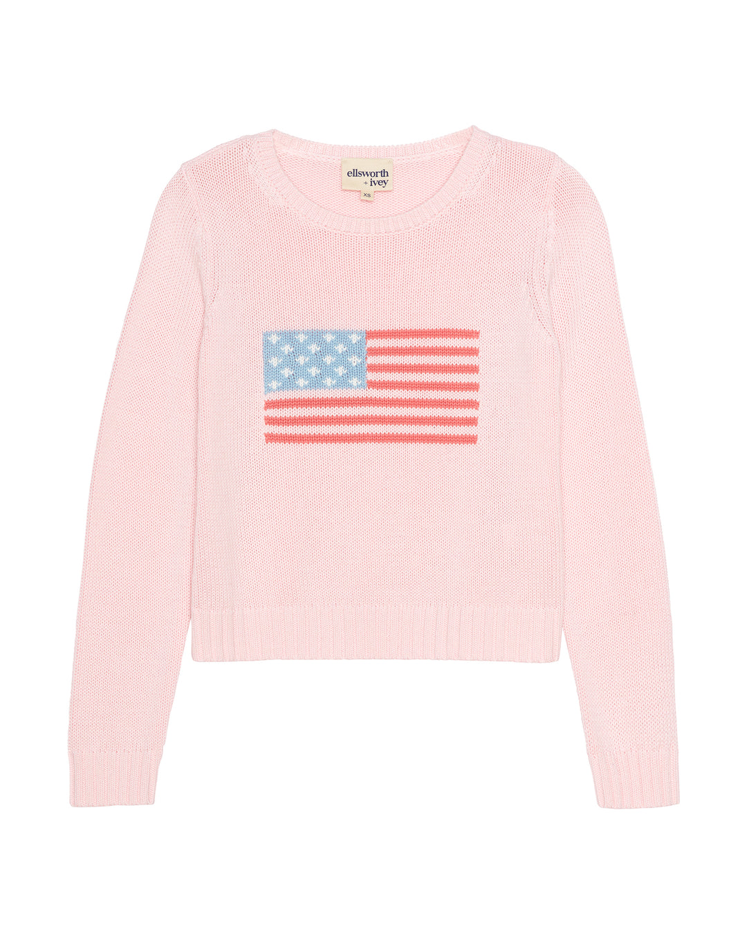 A light pink knit women's sweater with a knitted American flag graphic on the chest, featuring a crew neck and long sleeves. Autumn Crew - American Flag by Ellsworth + Ivey.