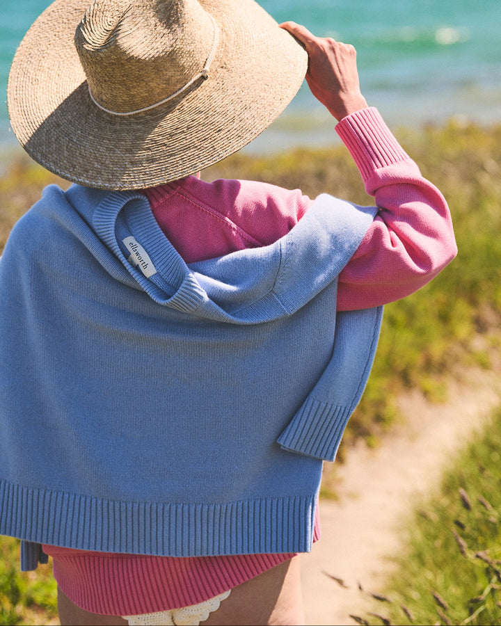 Woman on a beach wearing a pink sweater with a light blue crewneck cashmere women&