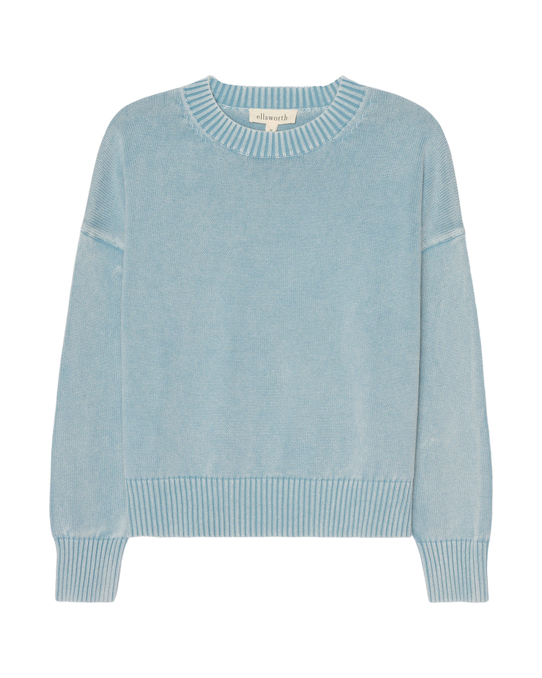 A light blue crewneck women's sweater with ribbed trim on the collar, cuffs, and hem, displayed flat against a white background. Emery Crewneck Sweater in Denim by Ellsworth & Ivey.
