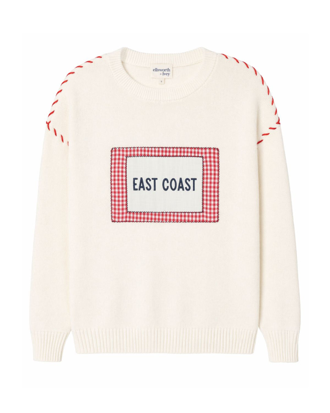 An ivory crewneck women's sweater featuring a red and white gingham checkered square patch on the chest with the text 'EAST COAST' printed in blue. The sleeves have red and white dashed whip stitching on the drop shoulders. Ellsworth + Ivey Riley Crew - East Coast.