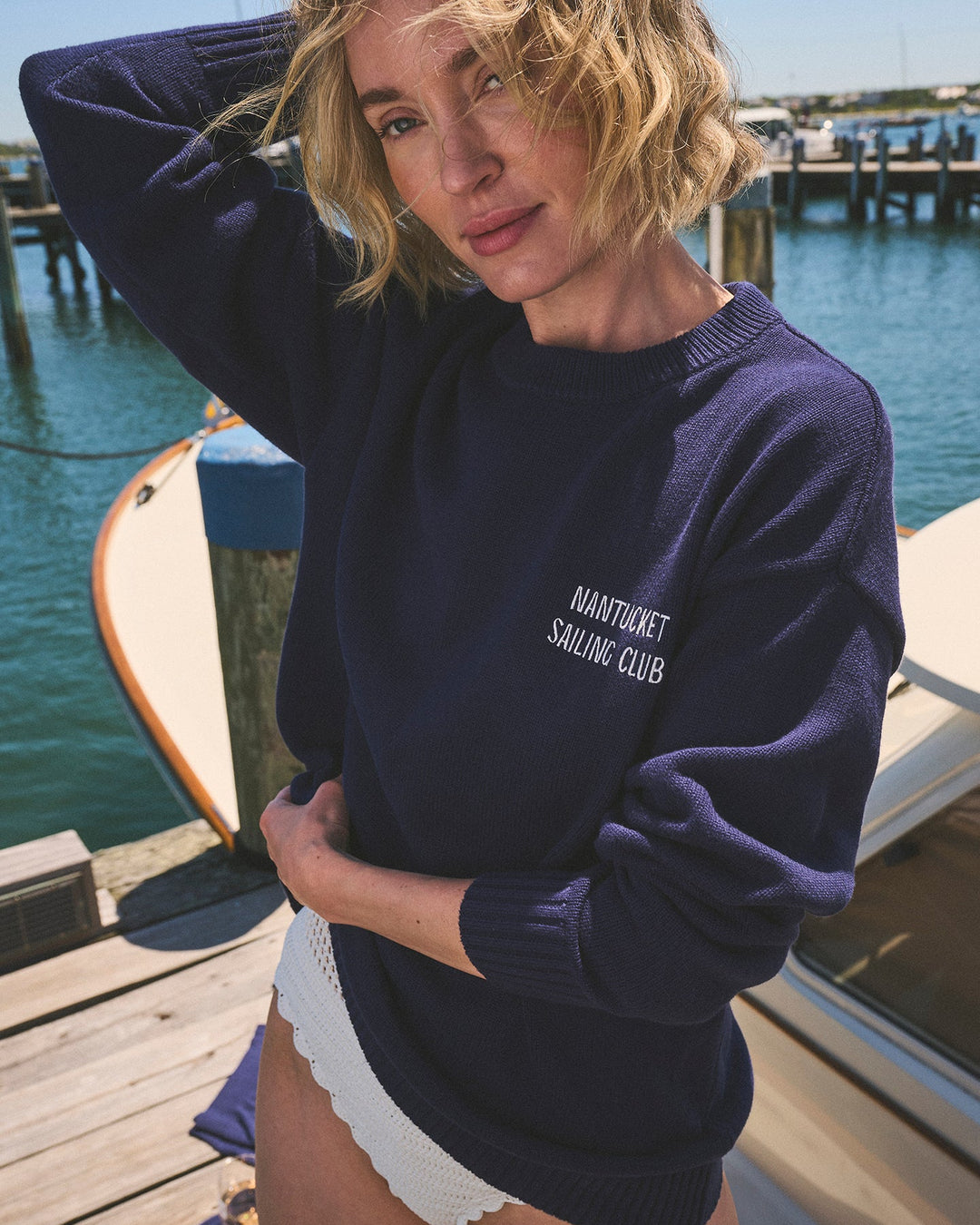 A woman wearing a navy blue crewneck oversized sweater with &