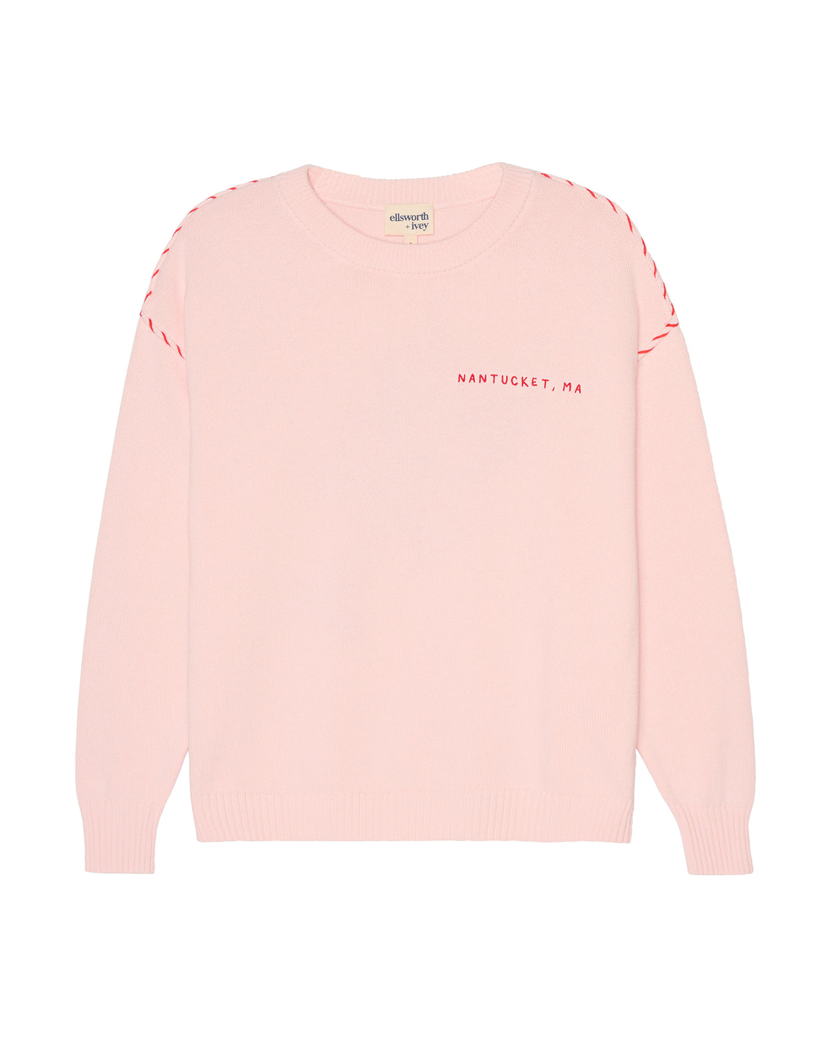 A light pink crewneck women's sweater with red dashed stitching along the shoulders and red text reading 'NANTUCKET, MA' on the left chest, shown on a plain white background. Riley Crew Sweater - ACK Lobster - Ellsworth + Ivey.