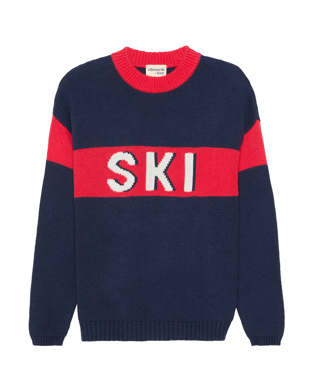 A navy blue knit sweater with a red horizontal chest stripe featuring the word 'SKI' in white letters, and red shoulder panels, shown on a plain white background. Sadie Crew - Ski in Navy by Ellsworth + Ivey.